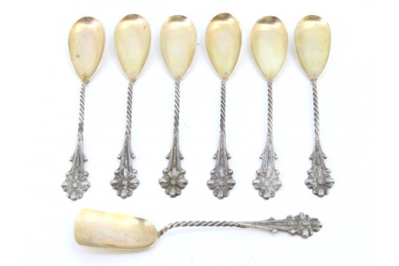 Conjunto de seis colheres de chá e pá de açúcar em prata com concha dourada com relevos nos cabos retorcidos.